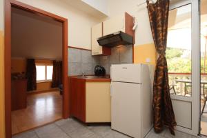 eine Küche mit einem weißen Kühlschrank und einem Balkon in der Unterkunft Apartments by the sea Kali, Ugljan - 8234 in Kali