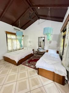 1 dormitorio con 2 camas y espejo. en Tiger Residency Resort, en Sauraha