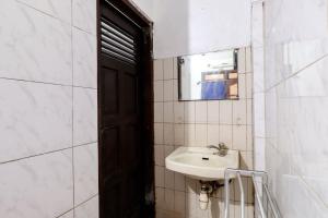 La salle de bains est pourvue d'un lavabo et d'un miroir. dans l'établissement Hotel Gajah Mada, à Sukodono