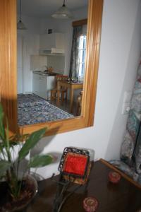 a living room with a mirror and a kitchen at Mavromatis Studios in Naxos Chora