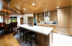 a kitchen with wooden cabinets and a kitchen island with a sink at Luxury Two Bedroom Corner Suite with Mountain Views apartment hotel in Park City