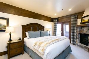 a bedroom with a large bed and a fireplace at Luxury Two Bedroom Corner Suite with Mountain Views apartment hotel in Park City