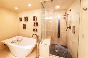 a bathroom with a shower and a tub and a sink at Luxury Two Bedroom Corner Suite with Mountain Views apartment hotel in Park City
