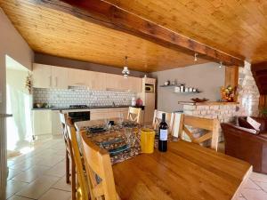a kitchen and dining room with a wooden table at Gîte chaleureux avec cheminée près du Puy-en-Velay, idéal pour familles et séjours professionnels - FR-1-582-349 in Saint-Germain-Laprade