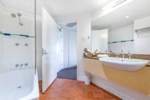 un bagno con lavandino, doccia e vasca di Two Private Oceanview Suites with Resort Pool a Darwin