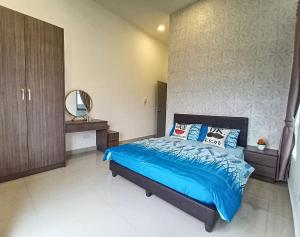 a bedroom with a bed with blue sheets and a mirror at ComfyHome at Palas Horizon Residence with sunrise view in Brinchang