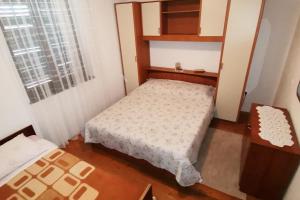 een kleine slaapkamer met een bed en een raam bij Apartments by the sea Lukoran (Ugljan) - 8397 in Lukoran