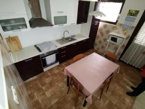 a small kitchen with a pink table and a sink at Apartments by the sea Lukoran (Ugljan) - 8397 in Lukoran +17 photos