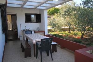 a patio with a table and chairs and a kitchen at Apartments by the sea Lukoran (Ugljan) - 8397 in Lukoran