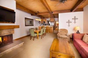 1 Bedroom Mountain Residence In The Heart Of Aspen With Amenities Including Heated Pool, Hot Tubs, Game Room And Spa في أسبين: غرفة معيشة مع أريكة وطاولة