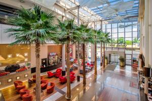 a lobby with palm trees and furniture in a mall at Qubus Hotel Kraków in Kraków