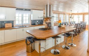 a kitchen with a wooden table and some chairs at Stunning Home In Tjrhom With Wifi And 8 Bedrooms in Tjørhom