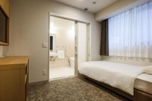 大阪的住宿－Plum Hotel，一间卧室设有一张床和一个滑动玻璃门