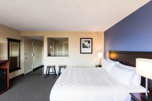 a hotel room with a bed and a table and chairs at Holiday Inn South Plainfield-Piscataway, an IHG Hotel in South Plainfield
