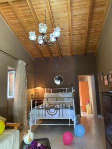 a bedroom with a bed and a ceiling with a chandelier at CASA THEOTOKI in Anemómylos