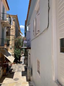 a narrow alley with a white building and a balcony at 1830 Chateau in Nafplio