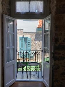 an open door to a balcony with a table and a table at 1830 Chateau in Nafplio