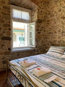 a bed in a room with a window with towels on it at 1830 Chateau in Nafplio