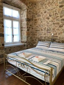 a bed in a room with a stone wall at 1830 Chateau in Nafplio