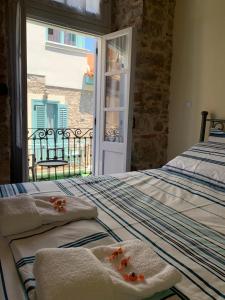 a bedroom with a bed with towels and a window at 1830 Chateau in Nafplio