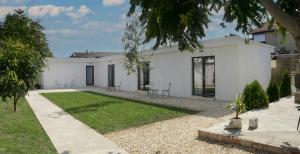 a white house with a lawn in front of it at The Crib Vama Veche in Vama Veche