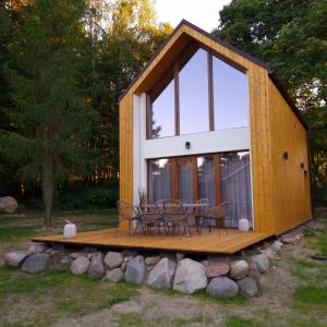 a cabin with a table and chairs on a deck at Domek Discovery Mazury in Mrągowo