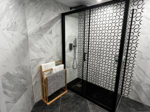 a shower in a bathroom with white marble walls at Wonderful Loft, parking free V in Málaga