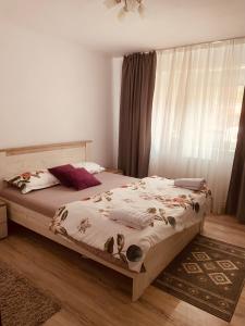 een slaapkamer met een bed met een deken erop bij APARTAMENT NOBLESS No1 ALBA IULIA in Alba Iulia