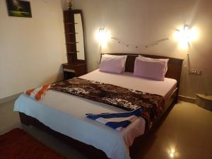 a bedroom with a large bed with purple pillows at Marina guest house in Kovalam