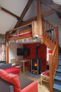 a living room with a loft bed and a fireplace at The Bake House in Llangennith