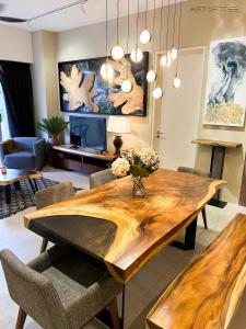 By The Sea Beachfront Designer Suites Penang - Managed by Art of Tree في باتو فيرينغي: غرفة طعام مع طاولة وكراسي خشبية