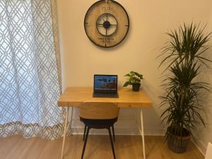 a laptop sitting on a table with a clock on the wall at Wonderful Loft, parking free V in Málaga