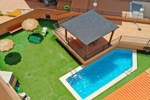 einen Blick über einen Hinterhof mit Pool und Gras in der Unterkunft Global Properties, Apartamento Ideal Familias en Canet Playa in Canet d'en Berenguer