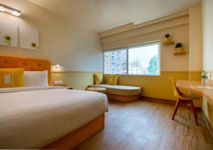 1 dormitorio con cama, escritorio y ventana en Bloom Hotel - HITEC City, en Hyderabad