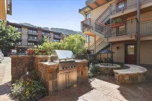 a outdoor grill in a yard next to a building at Luxury 2 Bedroom Mountain Vacation Rental In The Heart Of Downtown Aspen One Block From Silver Queen Gondola in Aspen