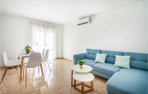 a living room with a blue couch and a table at Cozy Apartment In Torrevieja With Wifi in Torrevieja