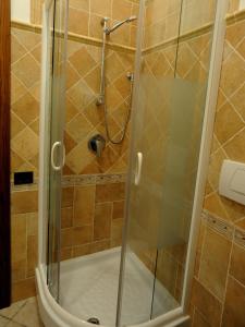 La salle de bains est pourvue d'une douche avec une porte en verre. dans l'établissement Villa dei Fantasmi, à Rocca di Papa