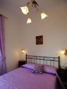 una camera da letto con un letto con copriletto viola di Villa dei Fantasmi a Rocca di Papa