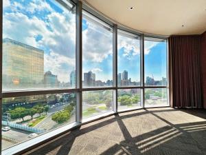 a room with a large window with a view of the city at Wallsun Hotel in Taipei
