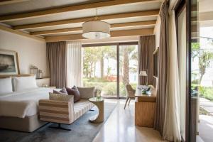 a bedroom with a bed and a chair and a window at Jumeirah Al Naseem Dubai in Dubai