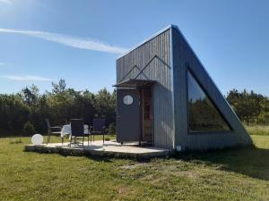una piccola casa con tavolo e sedie in un campo di Päikesemajake 1 a Hiiumaa