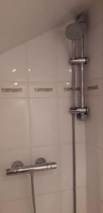 a bathroom with a shower with two metal racks at Chambre Aqualine in Aywaille