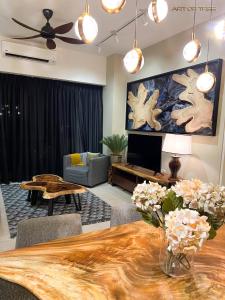 - un salon avec une table et une télévision dans l'établissement By The Sea Beachfront Designer Suites Penang - Managed by Art of Tree, à Batu Ferringhi