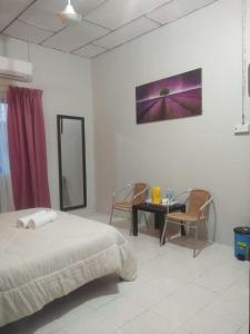 a bedroom with a bed and a table and chairs at Hana Guesthouse in Kuala Tahan +7 photos