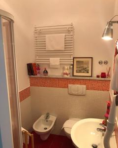 y baño con aseo y lavamanos. en Casa Tognetti en Migliarino