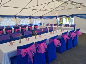 uma tenda montada para uma festa com mesas e cadeiras cor-de-rosa e azul em The Plough Inn Ripple em Deal