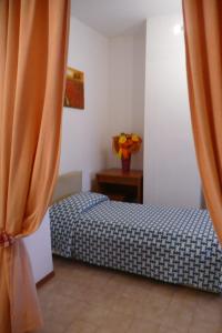 a small bedroom with a bed and a curtain at Hotel Ristorante Il Gabbiano in Cecina