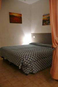 a bedroom with a bed with a black and white comforter at Hotel Ristorante Il Gabbiano in Cecina