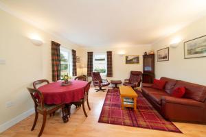 a living room with a couch and a table at Earnside Cottage in Comrie