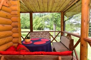 een tafel en stoelen op de veranda van een hut bij Sodyba “Rita” in Mėčiūnai